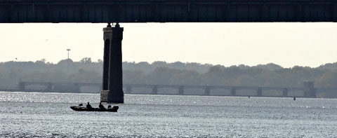 Photo of fishermen under a bridge